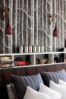 Monochrome tree patterned wallpaper and shelving in modern bedroom 