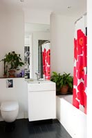 Modern white bathroom with colourful shower curtain 