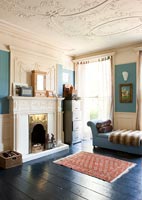 Vintage furniture, fireplace and period details in eclectic bedroom 
