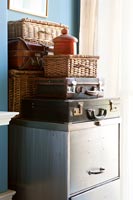 Vintage suitcases and hampers on old metal filing cabinet 