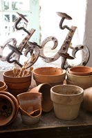 Collection of terracotta plant pots and rusted candle sconces 