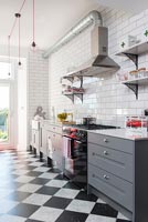 Modern grey kitchen with black and white checkered flooring 