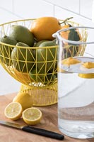 Lemons and limes in yellow fruit basket 