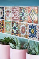 Patterned tiling at back of sink in country kitchen 