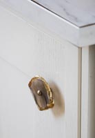 Gilded stone door knob on cabinet 