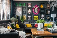 Eclectic living room with black painted walls and modern artworks