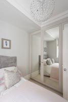 Modern bedroom with mirrored wardrobe doors 