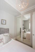 Modern bedroom with mirrored wardrobe doors 