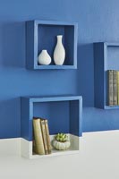 Box shelves on painted wall in half blue half white 