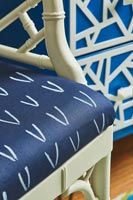 Blue and white patterned cushion on painted wooden chair 