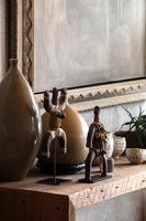 African artworks and vases on wooden shelf 
