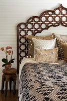 Decorative carved wooden headboard on bed 