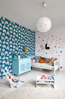 Childrens room with bold print wallpaper on feature wall 