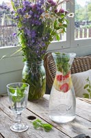 Country dining room table with flowers in vase and water jug