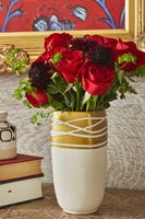 Red roses flowering arrangement in gold vase 