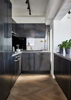 Contemporary black kitchen with herringbone wooden floor