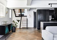 Contemporary open plan apartment with herringbone wooden floor