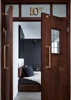Wooden double doors to modern monochrome bedroom 
