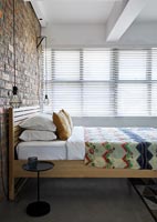 Modern bedroom with exposed brickwork wall 