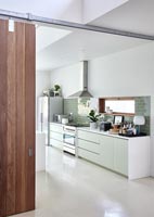 Modern white kitchen with green splashback tiling 