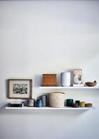 Ceramic pots and other ornaments on white shelves 