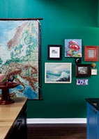 World map and paintings on green wall 