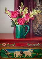Colourful flower arrangement on decorative sideboard 