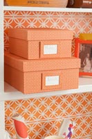 Orange cardboard boxes on bookcase shelves 