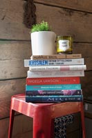Pile of books on red stool 