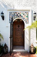 Wooden front door with mosaic above porch 