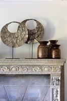 Carved mantelpiece with metal and ceramic ornaments 