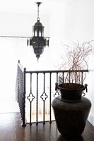 Modern landing with metal urn and decorative pendant light