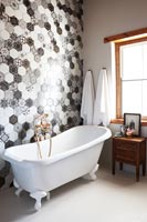 Black and white patterned tiled wall in modern bathroom 
