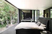 Modern monochrome bedroom with open sliding doors to garden 