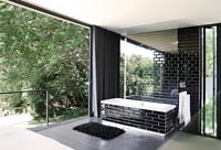 Modern monochrome en-suite bathroom with open sliding doors to garden 