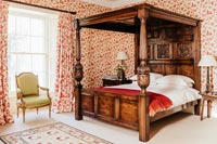 Bedroom with large wooden four poster bed 