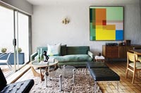 Modern living room with colourful painting on wall 
