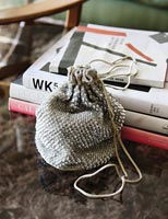 Small draw string purse and pile of books 