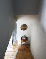 View down whitewashed staircase with tiled floor 