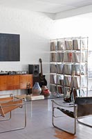 Vinyl records on shelves in room with musical instruments 