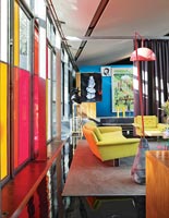 Colourfully painted windows in open plan living space 
