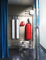 Punch bag and boxing gloves in home gym 
