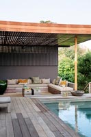 Modern seating area by swimming pool 