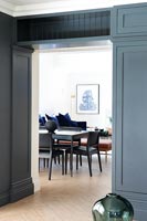 View through doorway to black dining table and chairs 