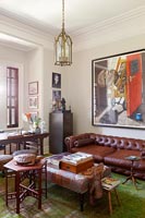 Vintage leather sofa and modern art in living room 