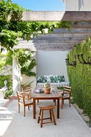 Garden table and chairs on terrace with living wall 