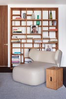 Modern chair in front of wooden shelving 
