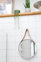 White tiled bathroom detail of mirror