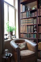 Leather armchair next to bookcase 