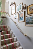 Striped runner carpet up stairs in country house